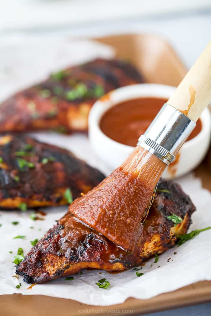 bbq sauce being brushed on bbq chicken