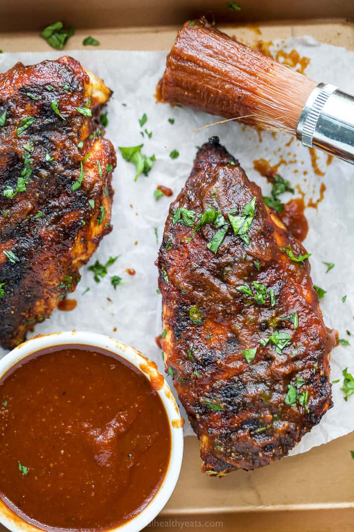 overhead photo of best ever bbq chicken on a sheet pan with bbq sauce covered brush