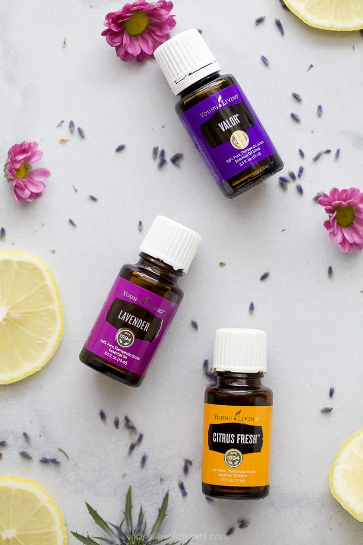 essential oils laid on a table with flowers around them