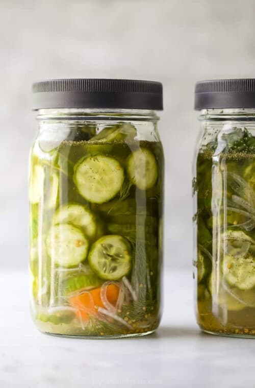 a mason jar filled with dill pickles and habanero peppers