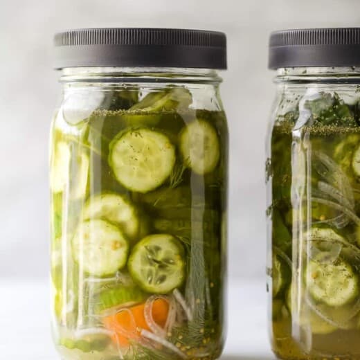 a mason jar filled with dill pickles and habanero peppers