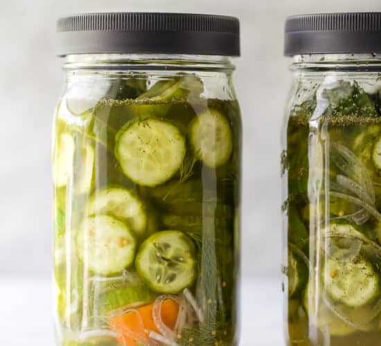 a mason jar filled with dill pickles and habanero peppers