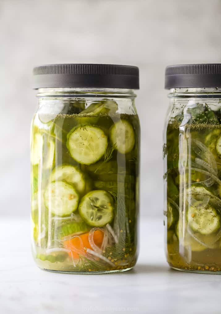 a mason jar filled with dill pickles and habanero peppers