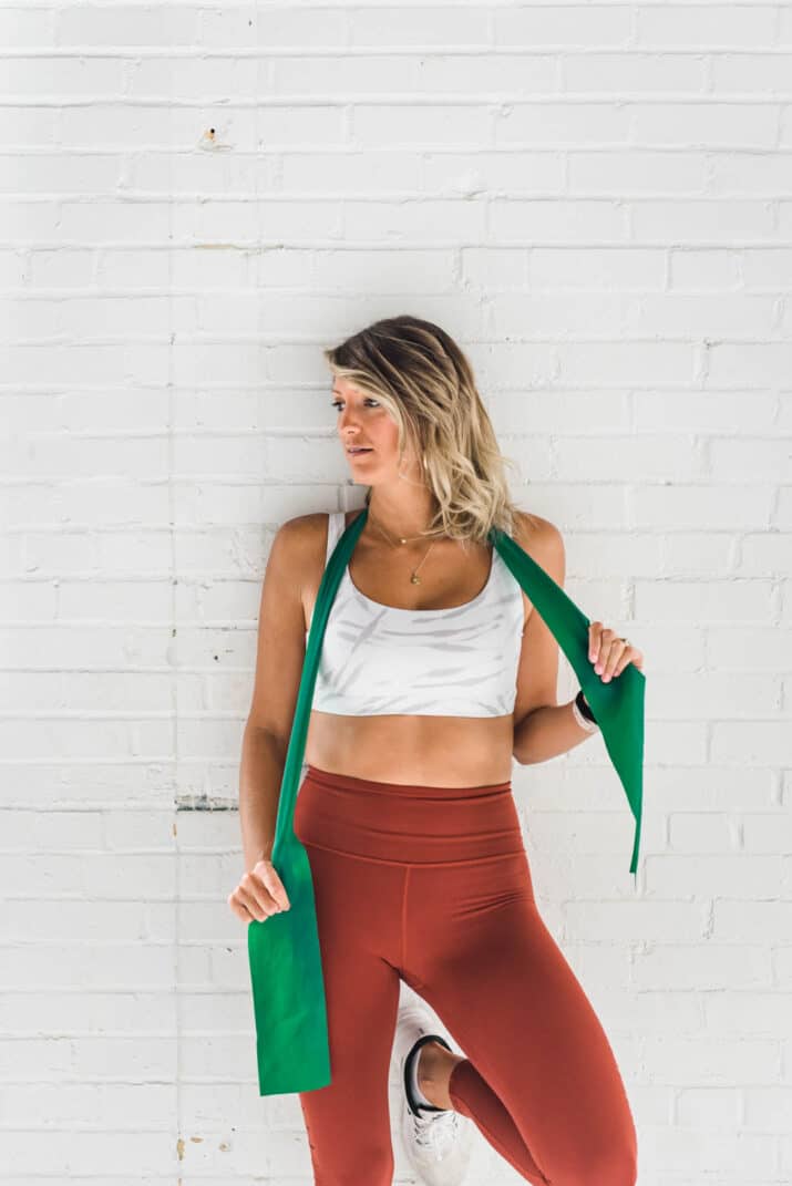 girl in workout gear holding a resistance band