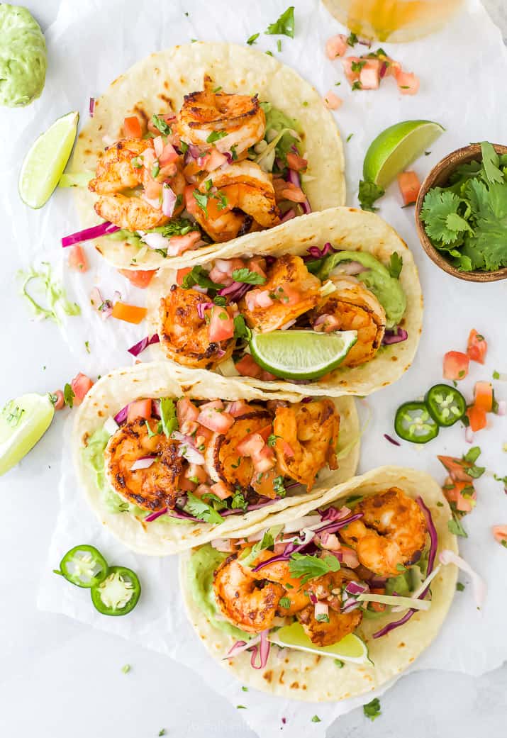 four spicy shrimp tacos piled up together