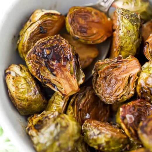 closet up of oven roasted brussel sprouts with balsamic in a bowl