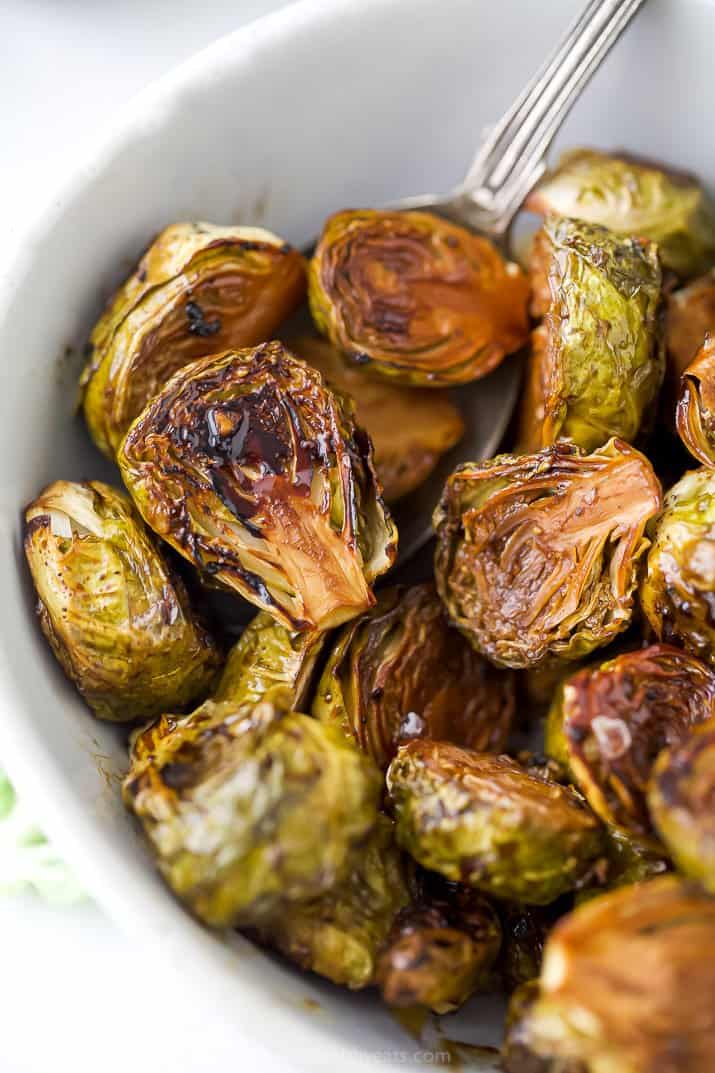 closet up of oven roasted brussel sprouts with balsamic in a bowl