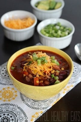 A Yellow Bowl of Crock Pot Chili Topped with Shredded Cheese