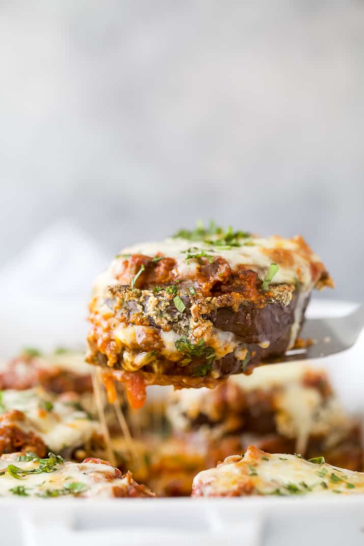 eggplant parmesan being pulled from a baking dish