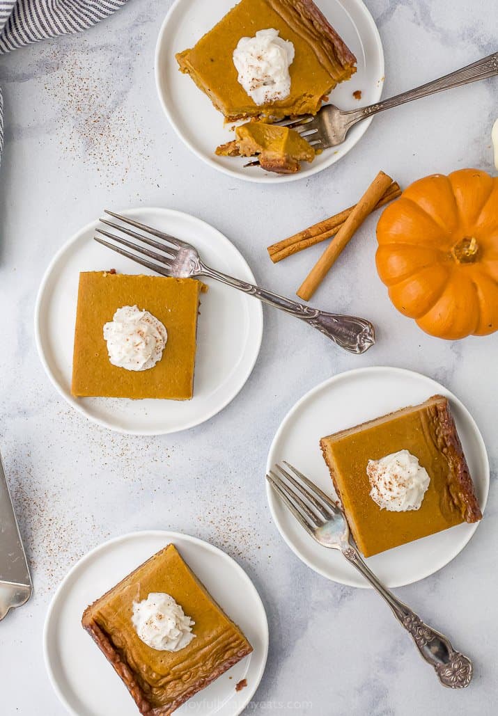 four plates with pumpkin pie bars on it