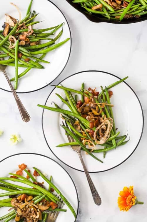 Green Bean Casserole is made with sautéed green beans, savory mushrooms and crispy bacon topped with homemade fried shallots. Healthy green bean casserole served on a plate.