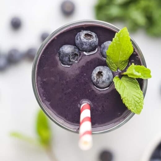 A Blueberry Protein Smoothie Garnished with Mint Leaves and Fresh Blueberries
