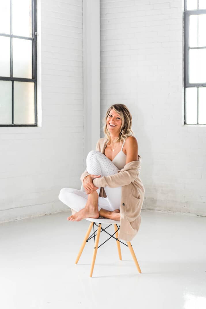 girl on a chair in workout gear smiling