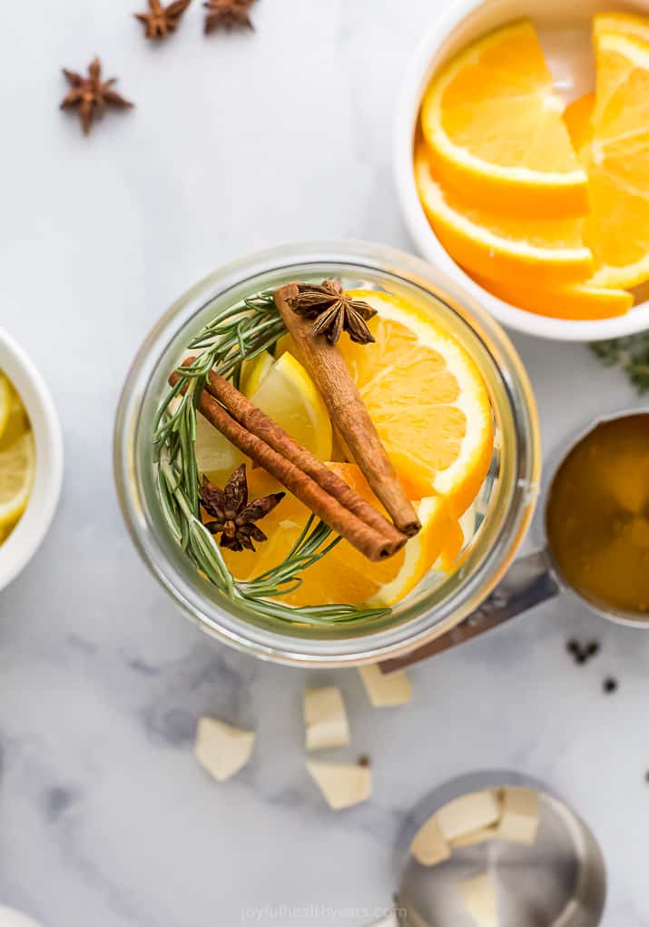 orange slices, rosemary sprig and cinnamon sticks in a mason jar