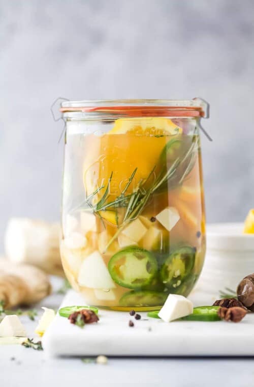 fire cider in a mason jar on top of a cutting board