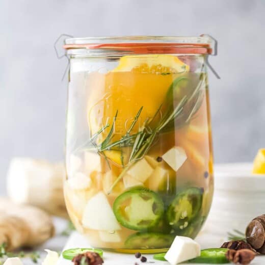 fire cider in a mason jar on top of a cutting board