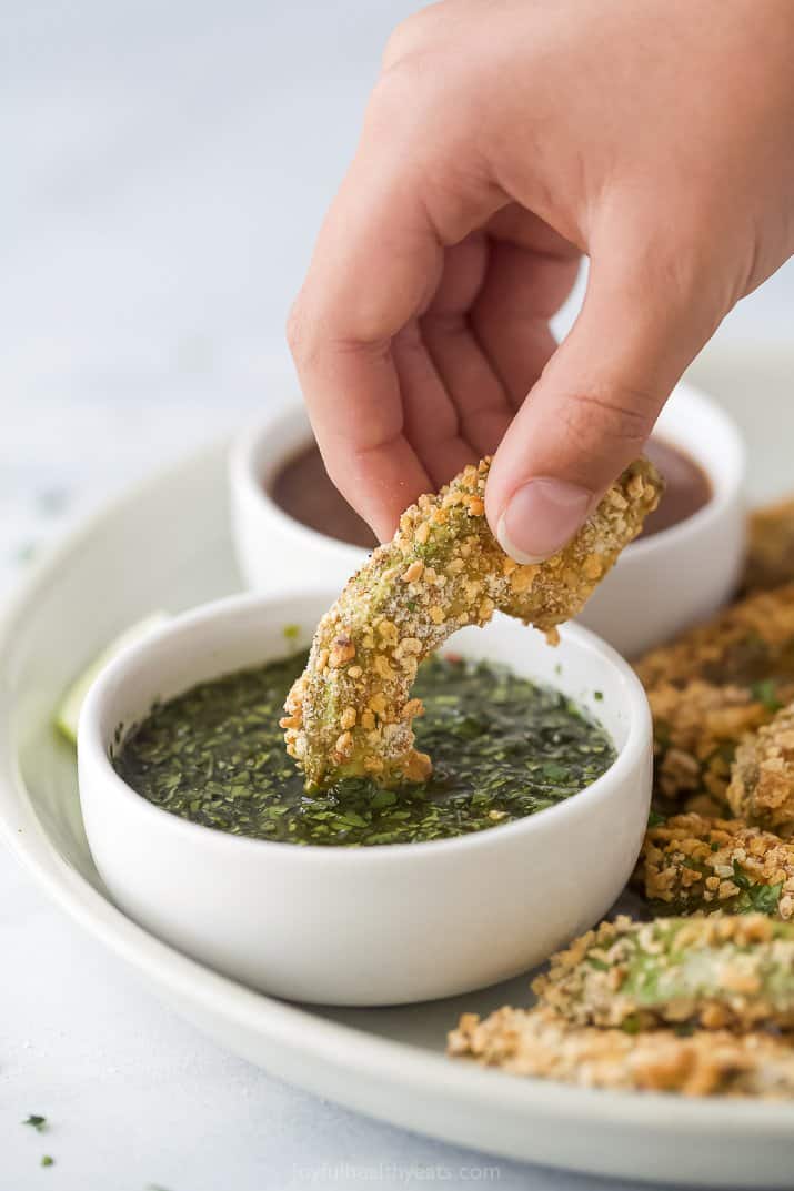 avocado fry being dunked into cilantro lime sauce