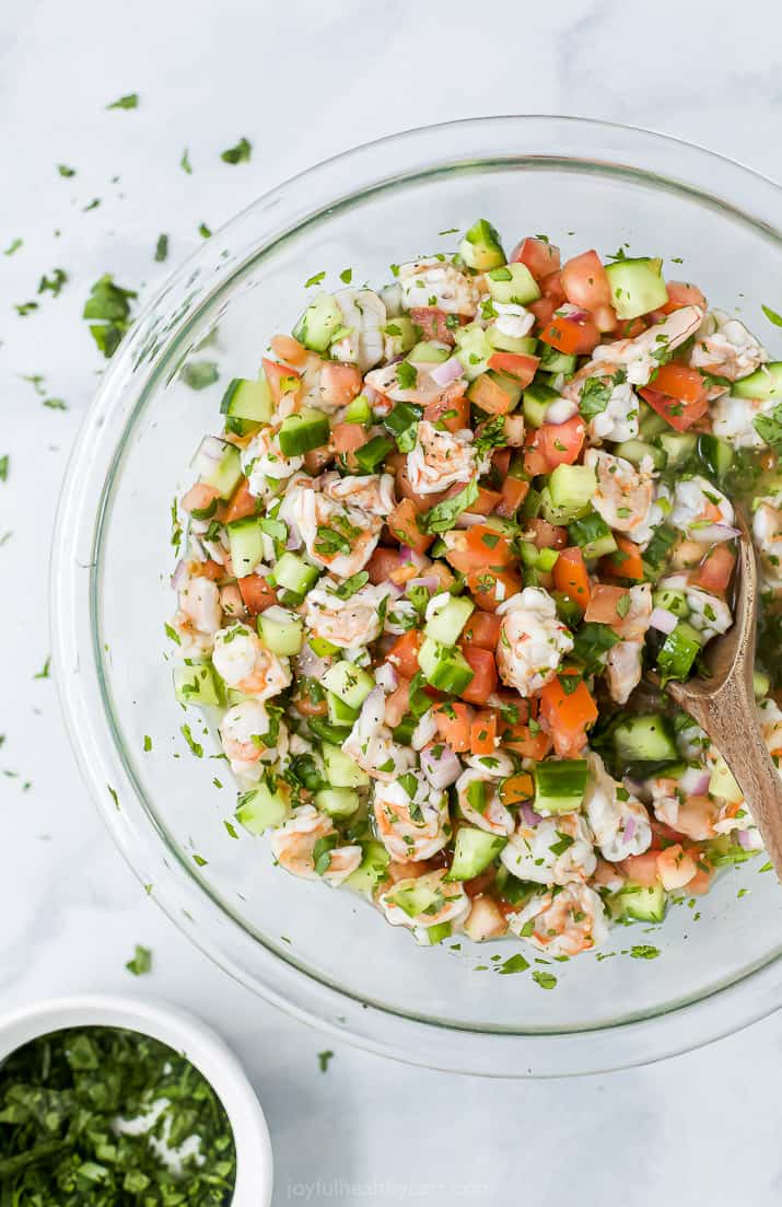 Fresh Shrimp Ceviche in a Glass Bowl Next to a Small Bowl of Cilantro