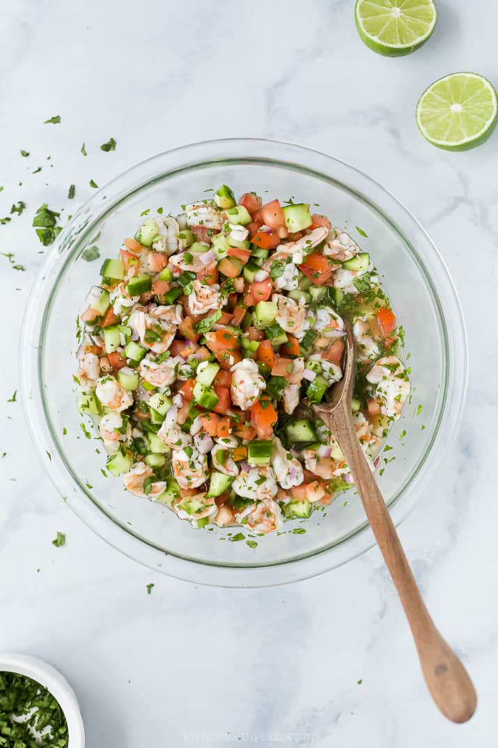 A Glass Bowl Filled with Seafood Ceviche and a Wooden Spoon