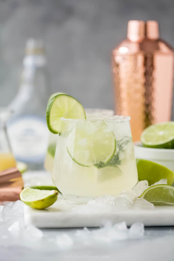 A Skinny Margarita in a Glass with a Cocktail Shaker in the Background