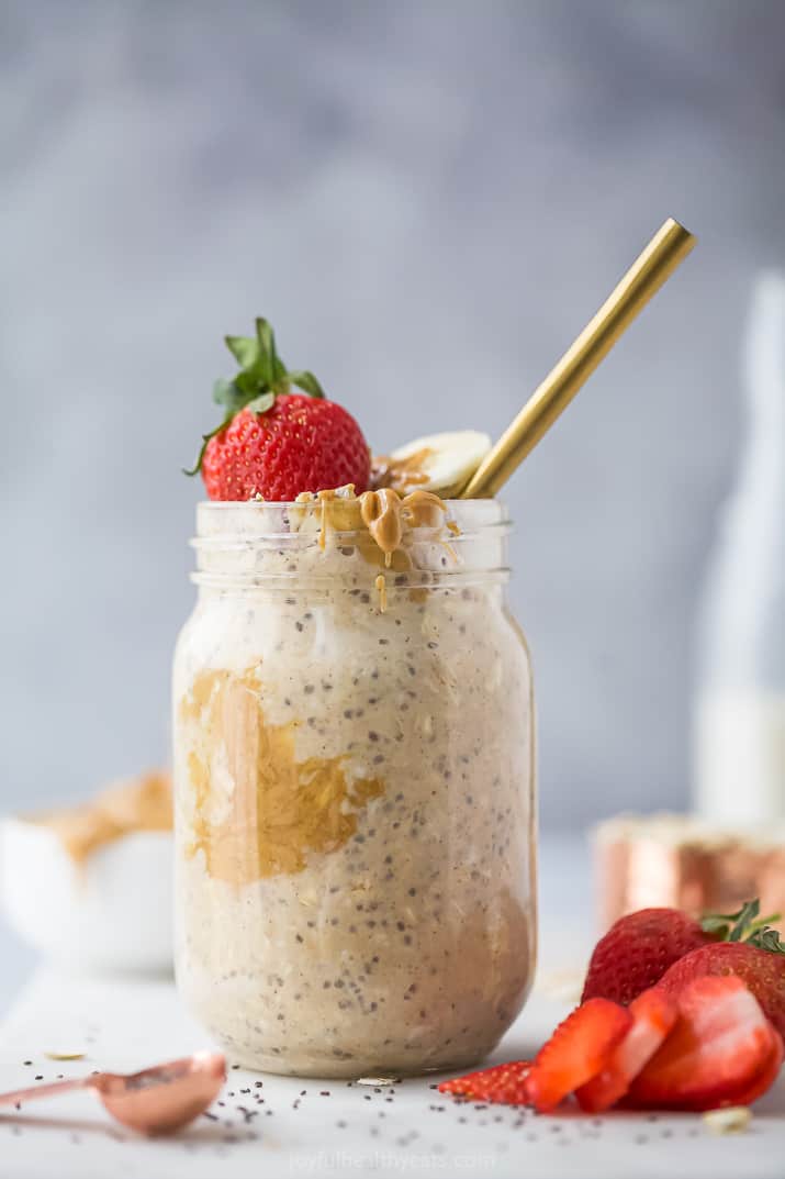 a mason jar with peanut butter overnight oats and strawberry garnish