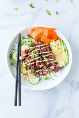 Chopsticks resting on tuna poke bowl.