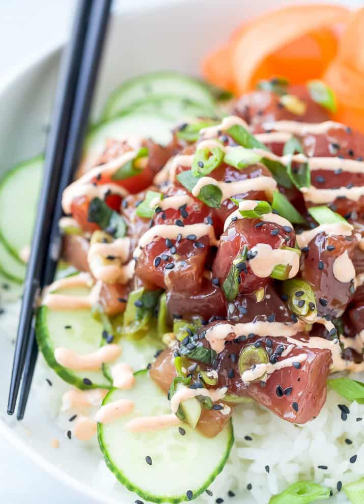 A Close-Up Image of a Tuna Poke Bowl Drizzled with Spicy Mayonnaise