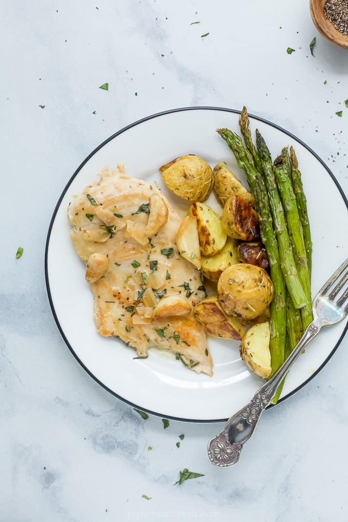 whole30 creamy garlic chicken on a plate with potatoes and asparagus