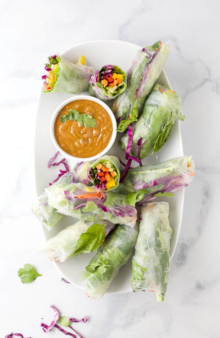 A Serving Dish Filled with Summer Rolls and a Small Bowl of Spicy Peanut Sauce