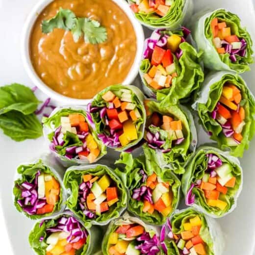 Veggie Rolls on a White Serving Plate with a Side of Peanut Dipping Sauce
