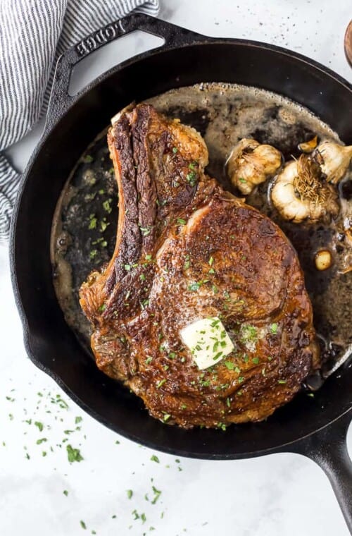 cowboy steak in a cast iron skillet with butter