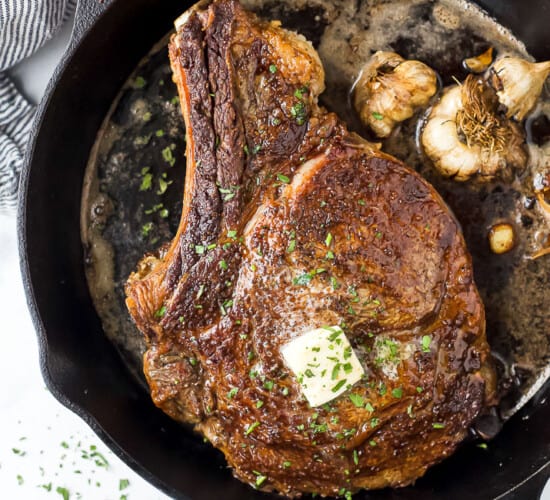 cowboy steak in a cast iron skillet with butter