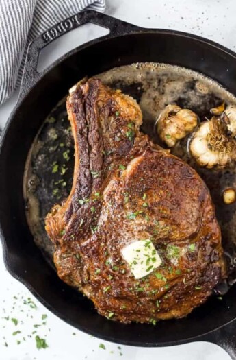 cowboy steak in a cast iron skillet with butter