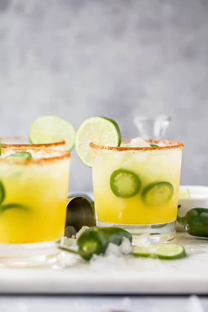 garnished glass with margarita and slices of jalapenos