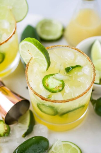 glass with spicy margaritas with jalapenos and lime