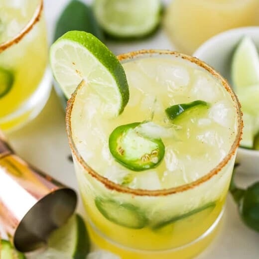 glass with spicy margaritas with jalapenos and lime