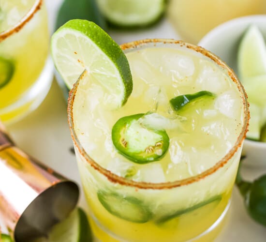 glass with spicy margaritas with jalapenos and lime