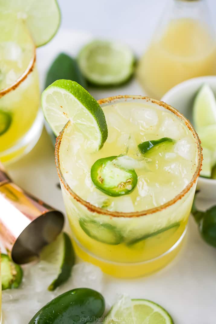 Glass with spicy margaritas with jalapenos and lime