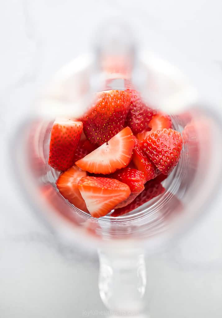 Strawberries in a large glass pitcher