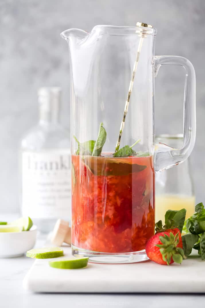 Muddled strawberries, lime juice, basil and vodka in a large glass pitcher