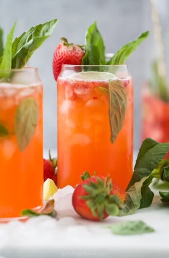 A strawberry cocktail garnished with a strawberry and basil leaf
