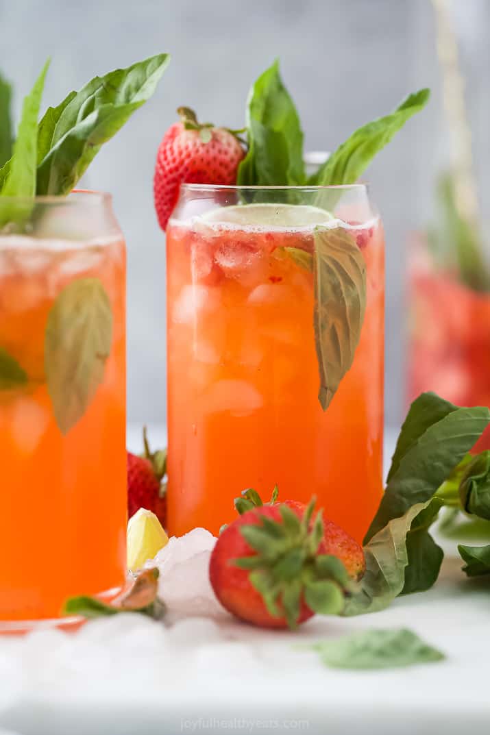 A strawberry cocktail garnished with a strawberry and basil leaf