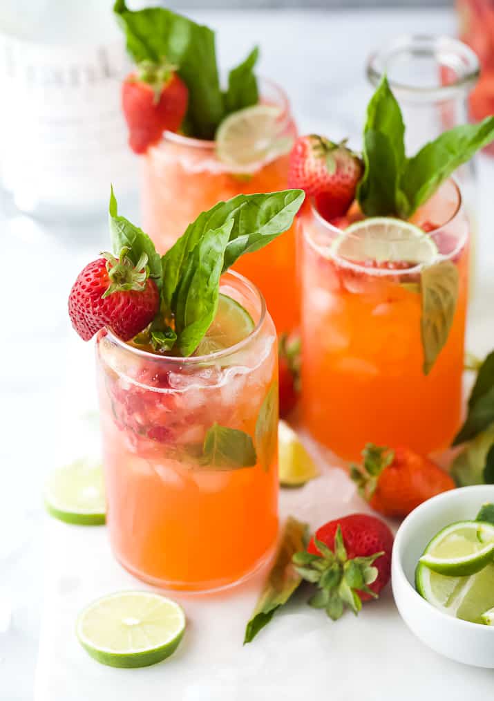 3 glasses of strawberry vodka cocktail with lime, strawberry and basil