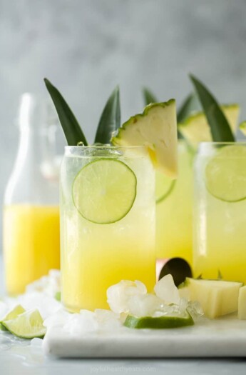 glass filled with pina colada spritzer with pineapple garnish