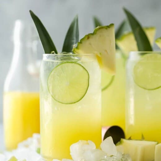 glass filled with pina colada spritzer with pineapple garnish