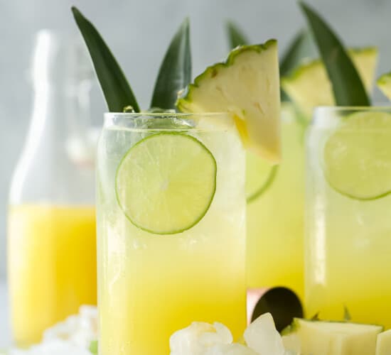 glass filled with pina colada spritzer with pineapple garnish