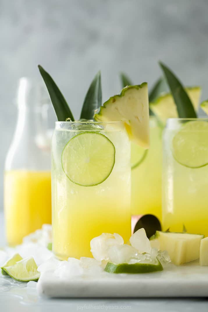 glass filled with pina colada spritzer with pineapple garnish