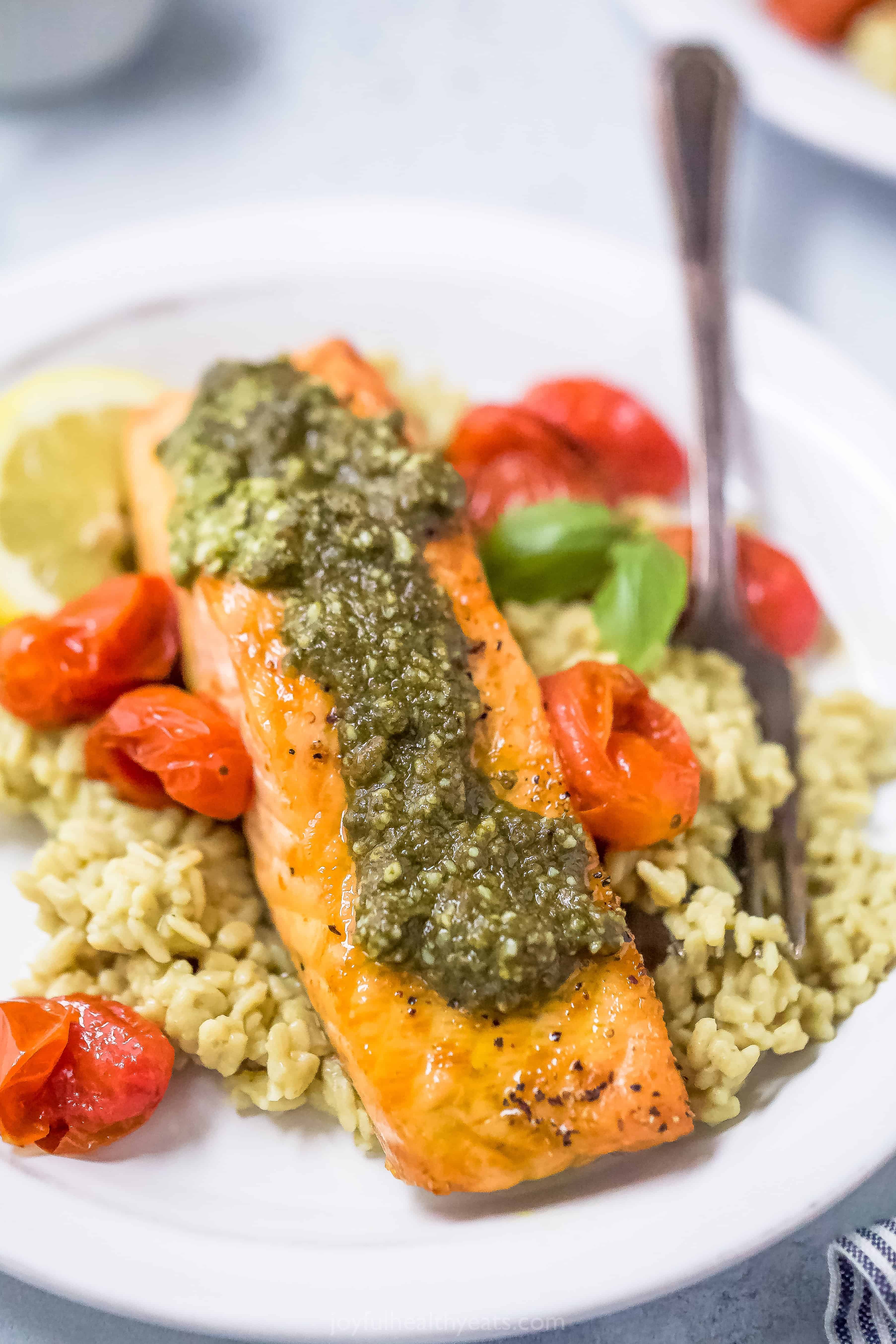 air fryer pesto salmon on top of rice with tomatoes