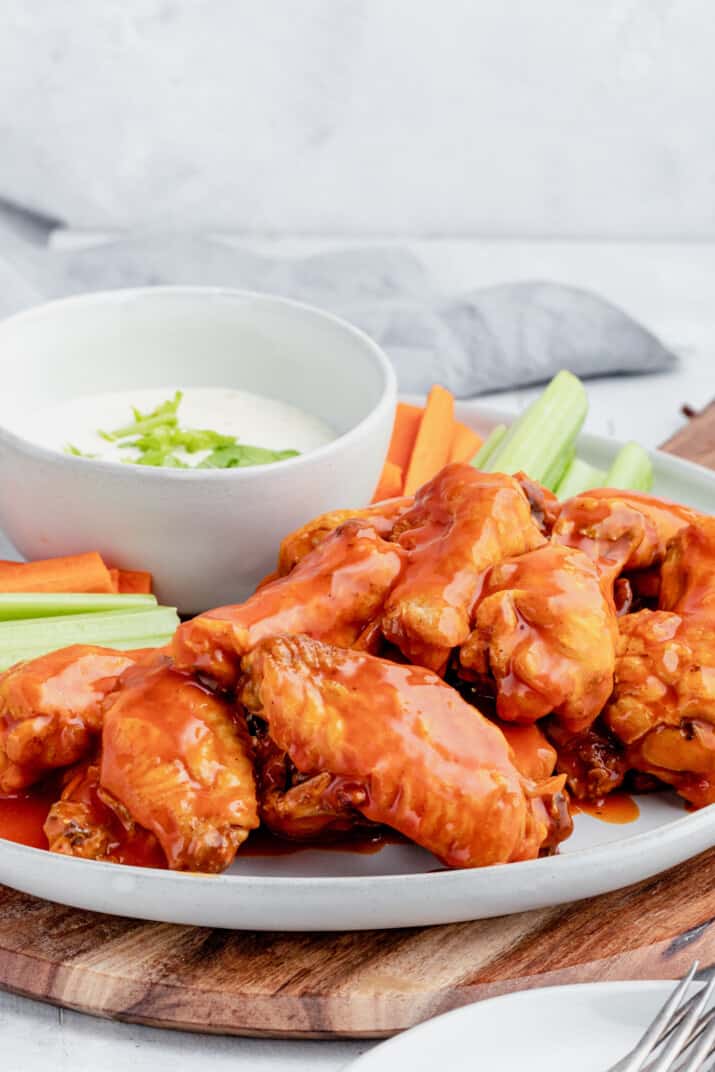 A Serving Platter Piled with Homemade Chicken Wings and Raw Vegetables