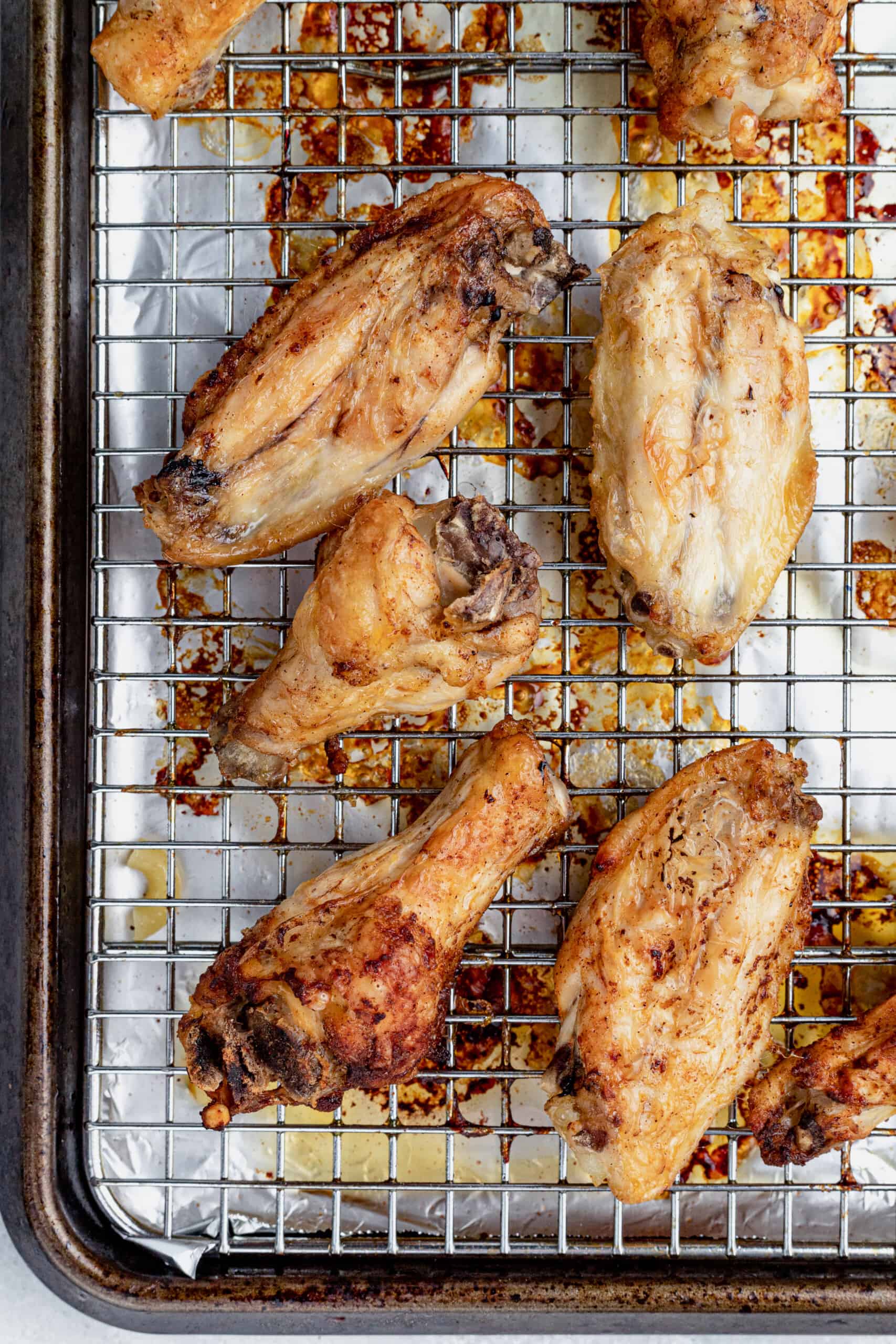 Baked Chicken Wings on a Wire Rack Over a Baking Sheet Lined with Aluminum Foil